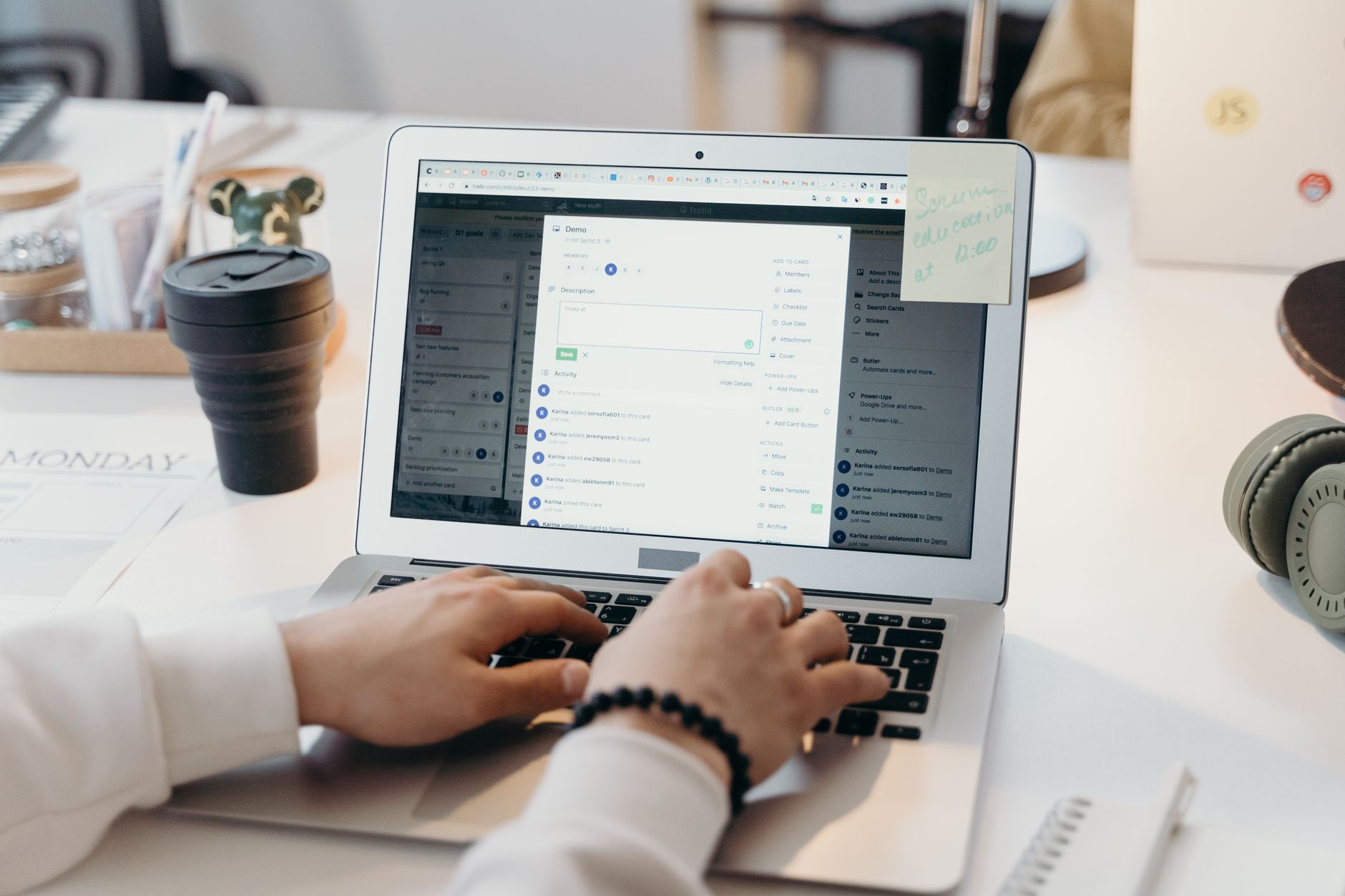 A person typing an email on a laptop at a desk with a coffee cup nearby.