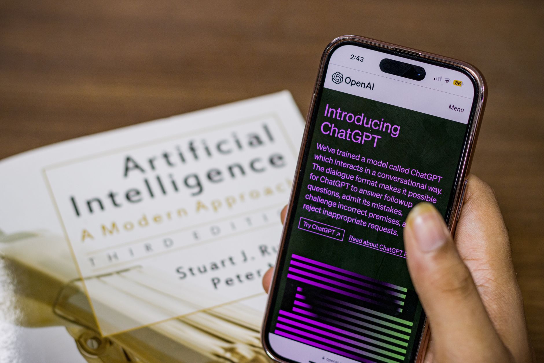 A person holds a smartphone showing the ChatGPT app on a bright kitchen counter