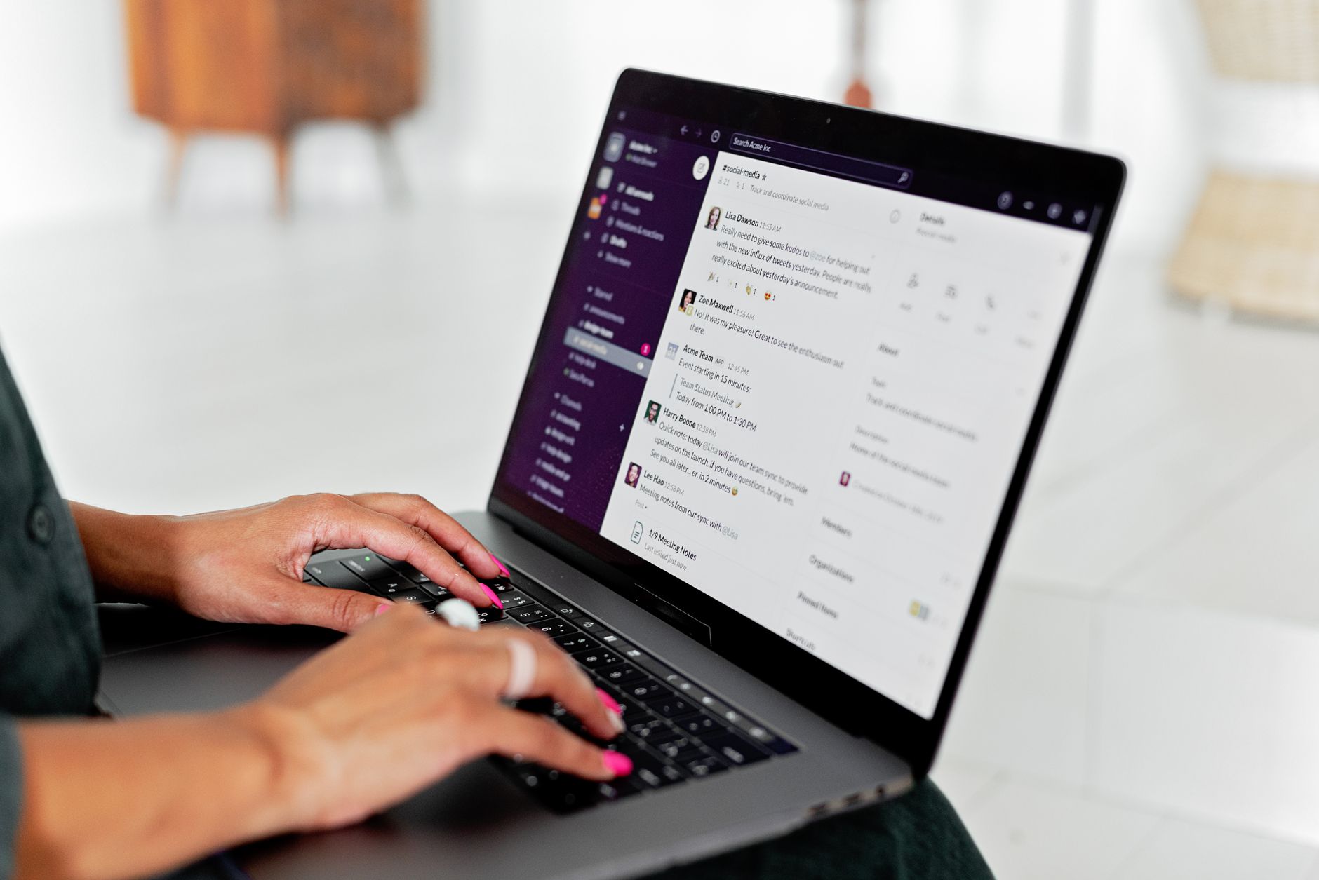 A person types on a laptop while an AI chat assistant window is visible on screen.