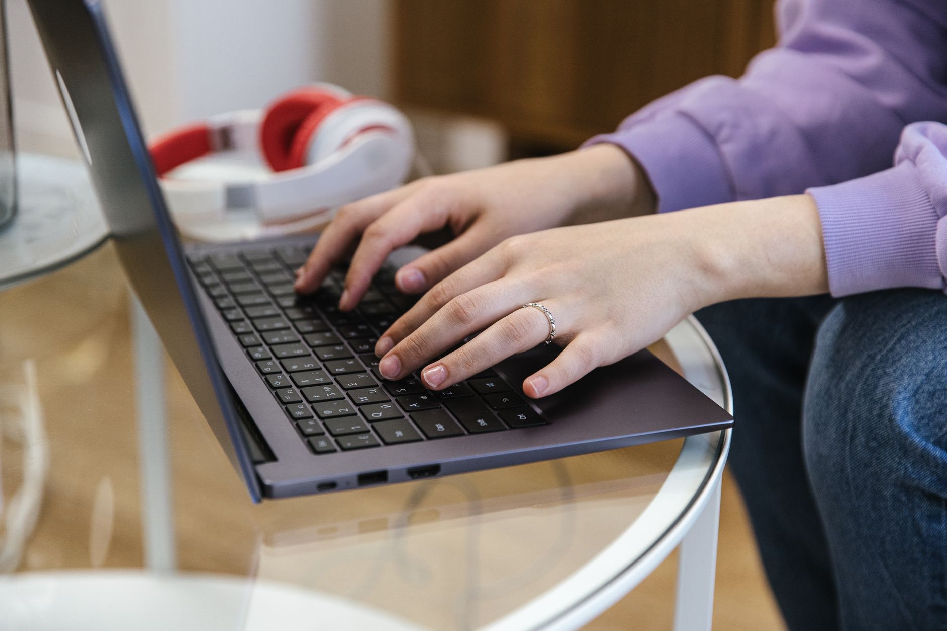 Person typing an email on a laptop at a tidy home desk with a cup of coffee nearby